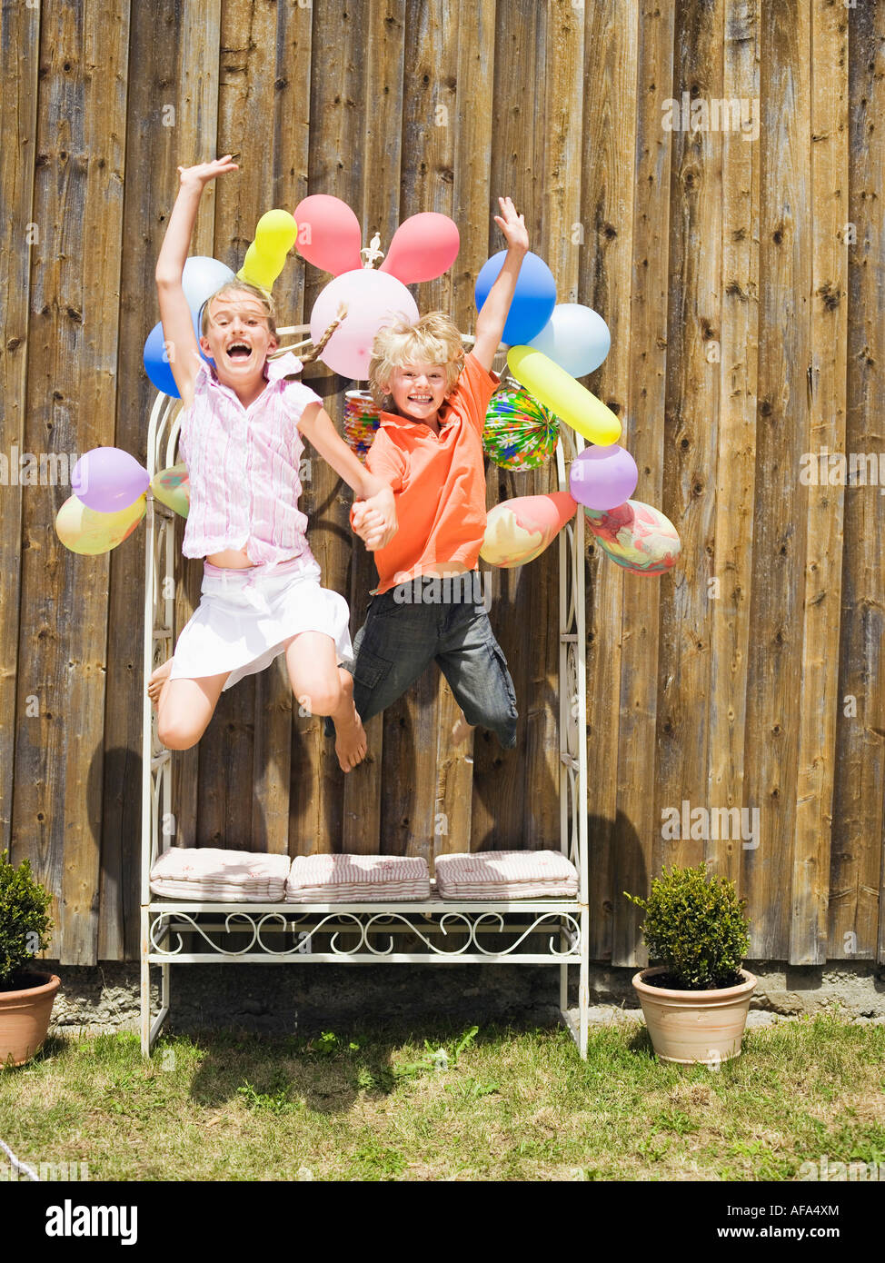 Boy and girl jumping, outdoors Stock Photo - Alamy