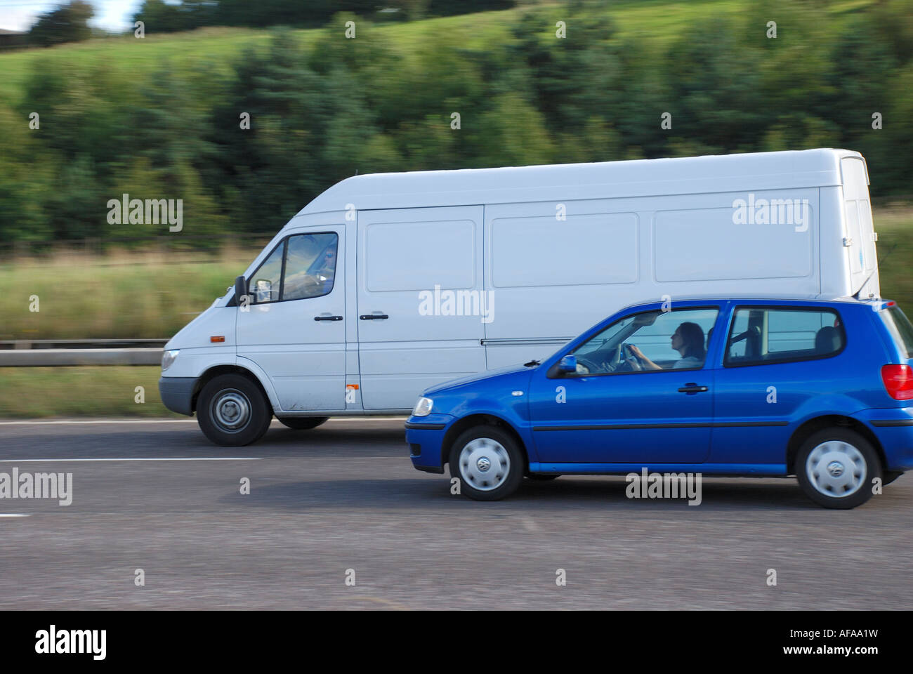 large white van passing blue car on the motor way. Stock Photo