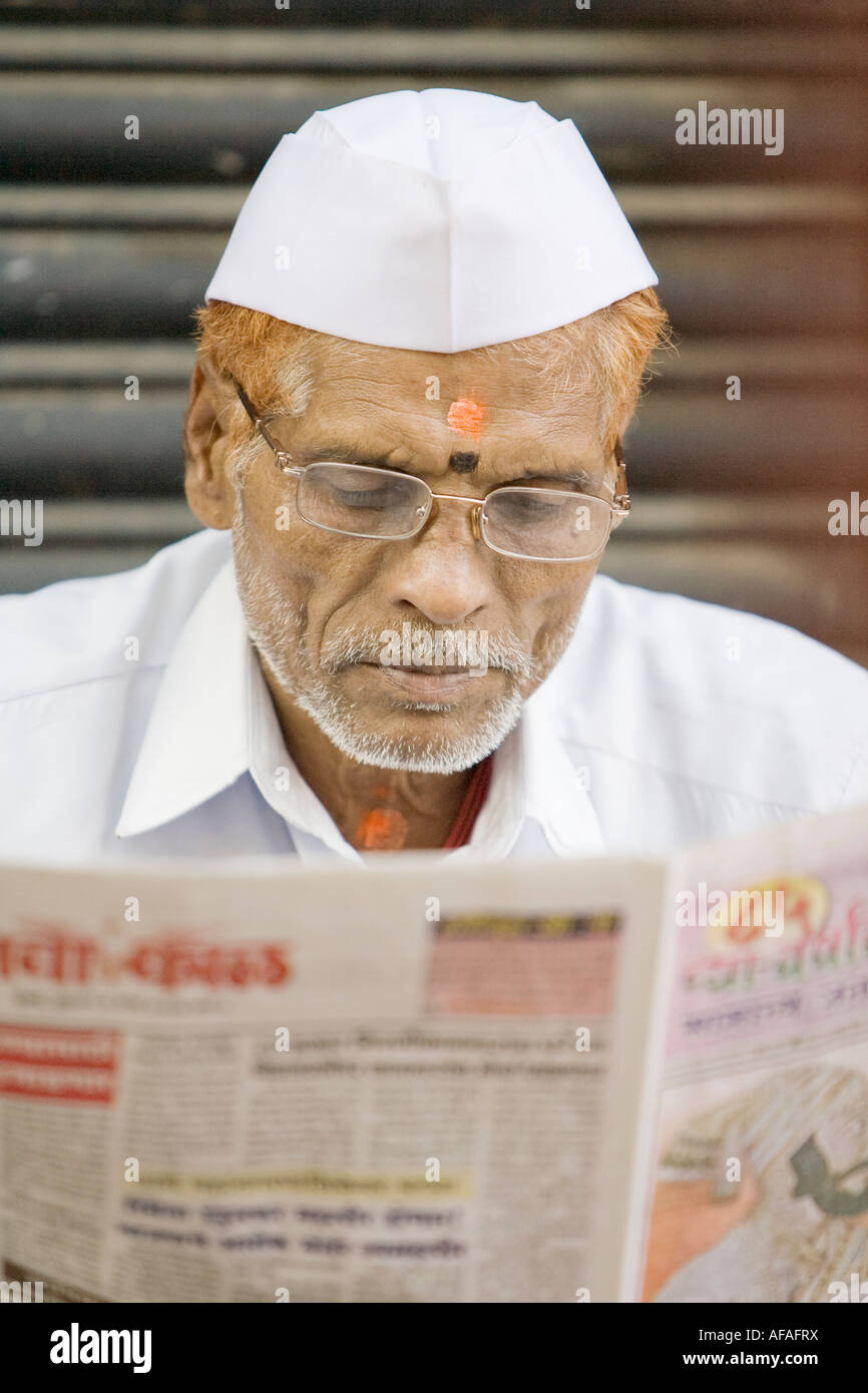 Indian man reading a newspaper Stock Photo - Alamy