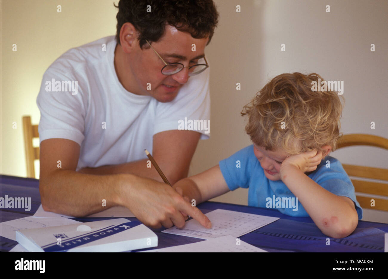 father helping young son with homework Stock Photo - Alamy