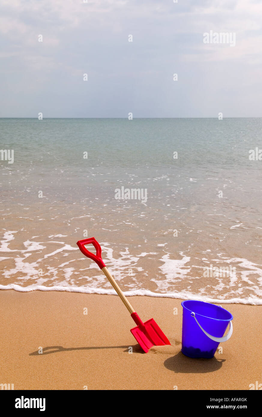 Bucket and spade on a sandy beach Stock Photo