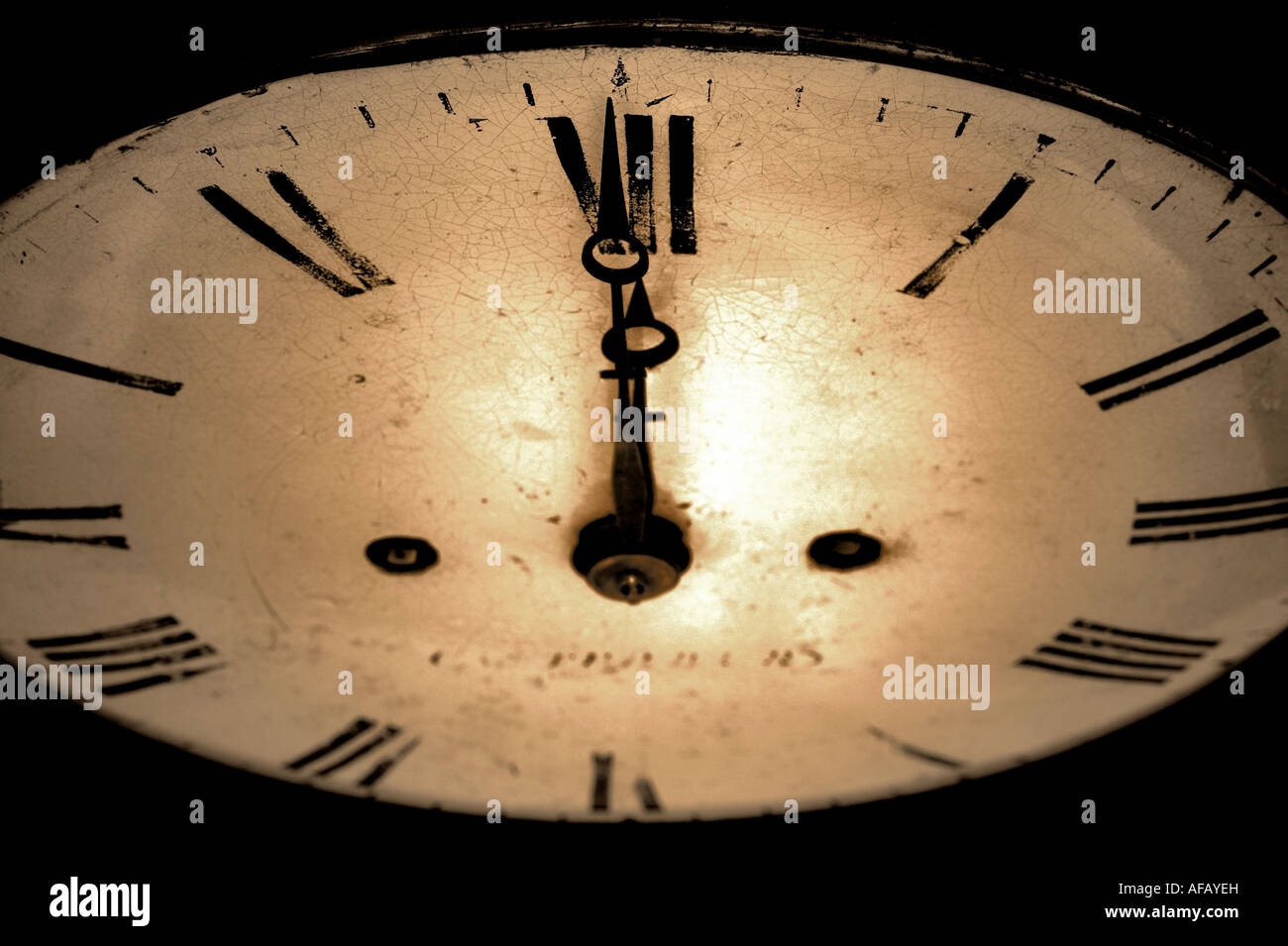 Antique clock face with the hands at 12 o clock dark and grainy sepia toned image Stock Photo