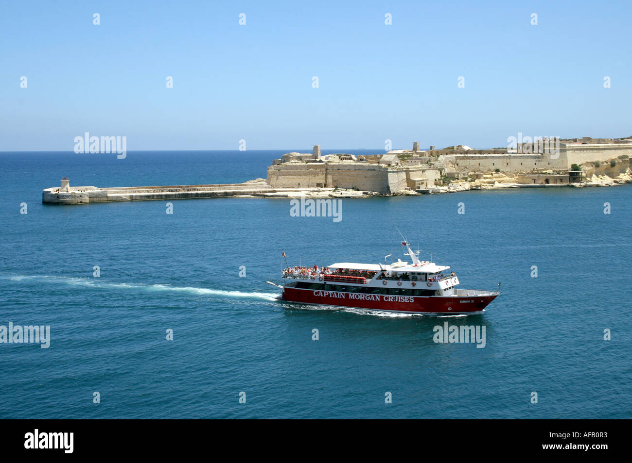 TOURIST LAUNCH PASSING FORT RICASOLI AT THE ENTRANCE TO GRAND HARBOUR. VALLETTA. MALTA EUROPE Stock Photo