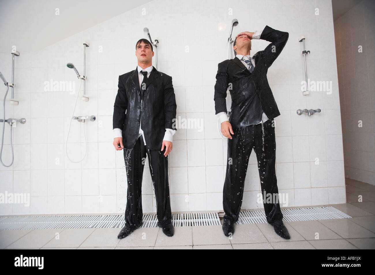 Businessmen standing under shower Stock Photo