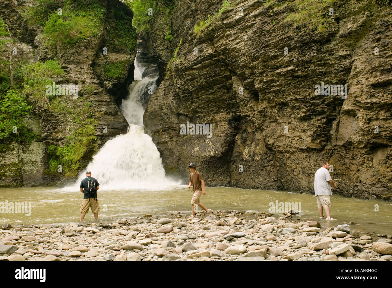Young men fishing for trout beneath waterfalls at Mine Kill State Park