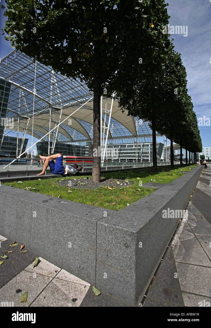 Illustration Airport Terminal: Traveller is sleeping at the parc of the modern Munich Airport building Stock Photo