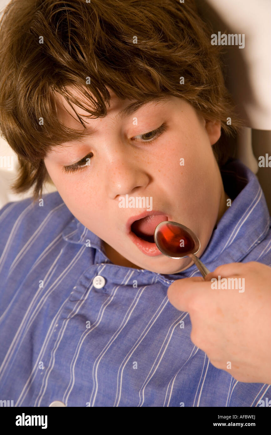 Child taking cough medicine to relieve cold and flu symptons. Stock Photo