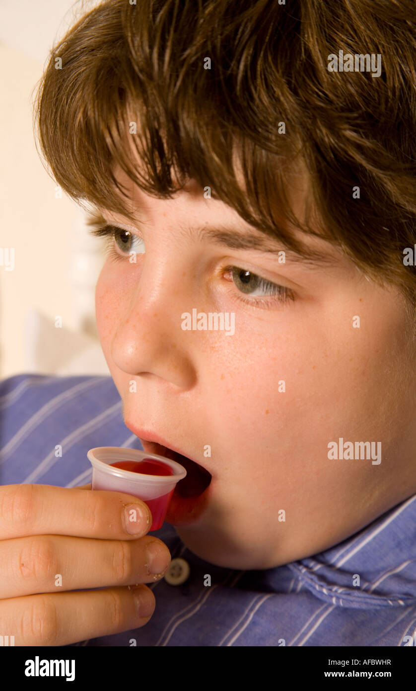 Young teenager taking cough syrup Stock Photo Alamy