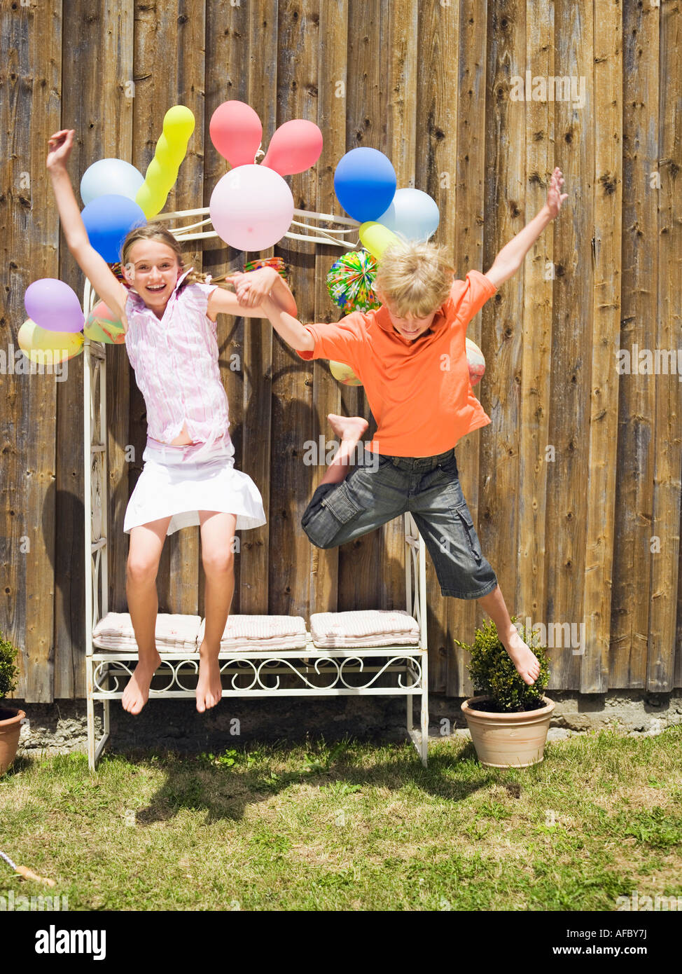 Boy and girl jumping, outdoors Stock Photo - Alamy