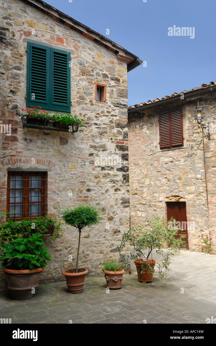 Stone buildings and potted plants in small piazza in San Donato in