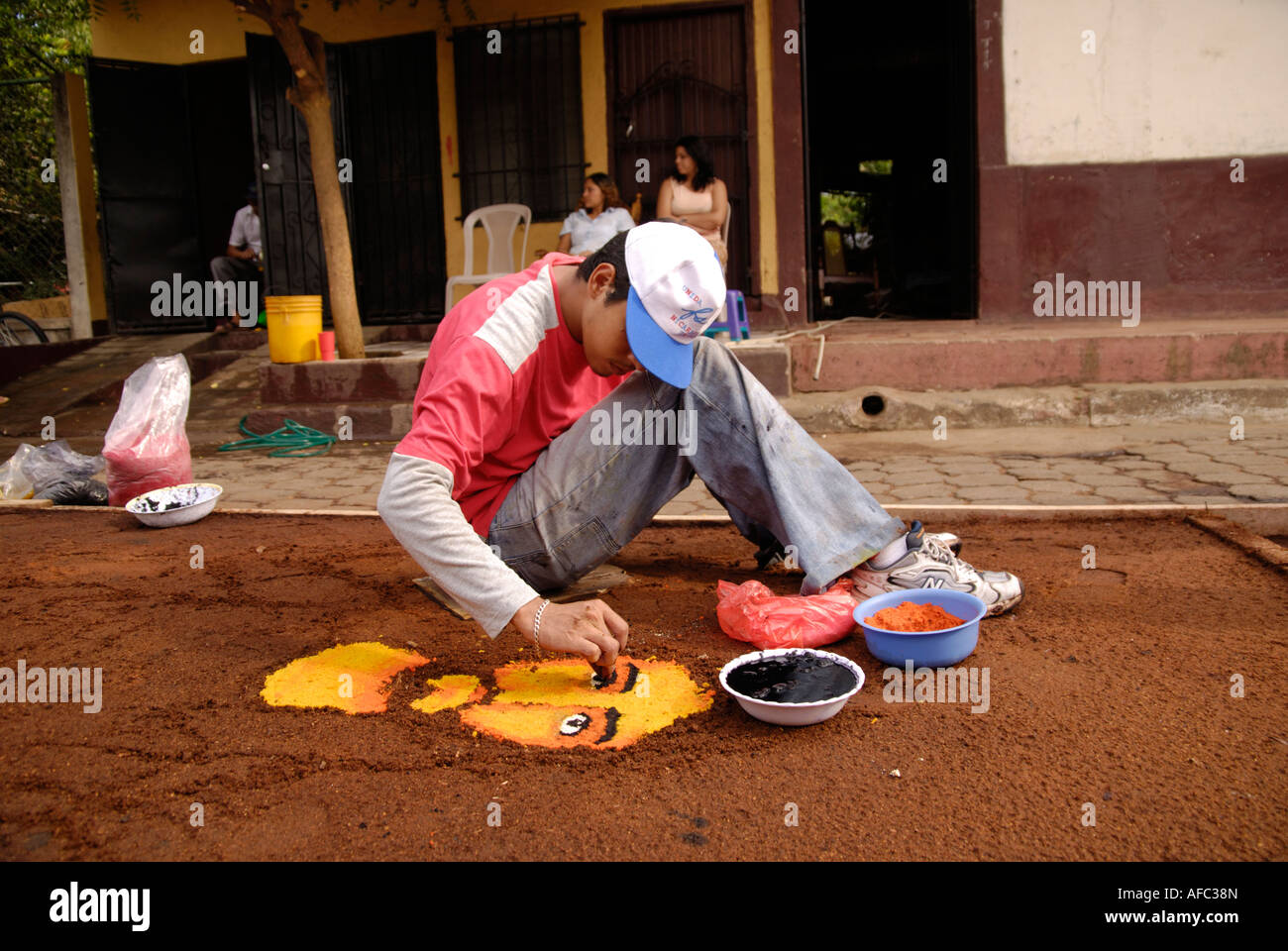 Young man designs a sawdust carpet for the Good Friday procession, Calle de las Alfombras, Leon Nicaragua Stock Photo