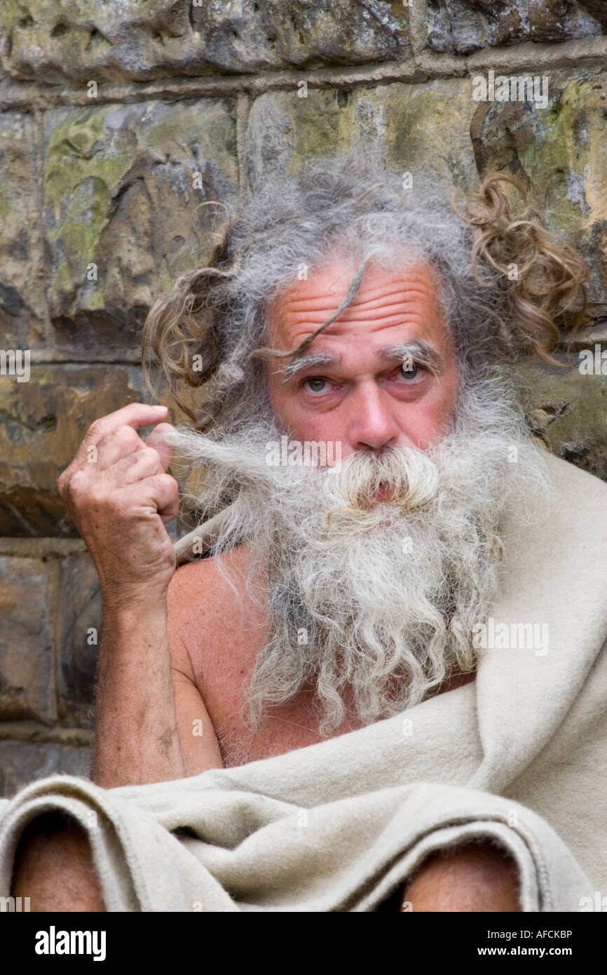 Homeless man plays with his beard Stock Photo - Alamy
