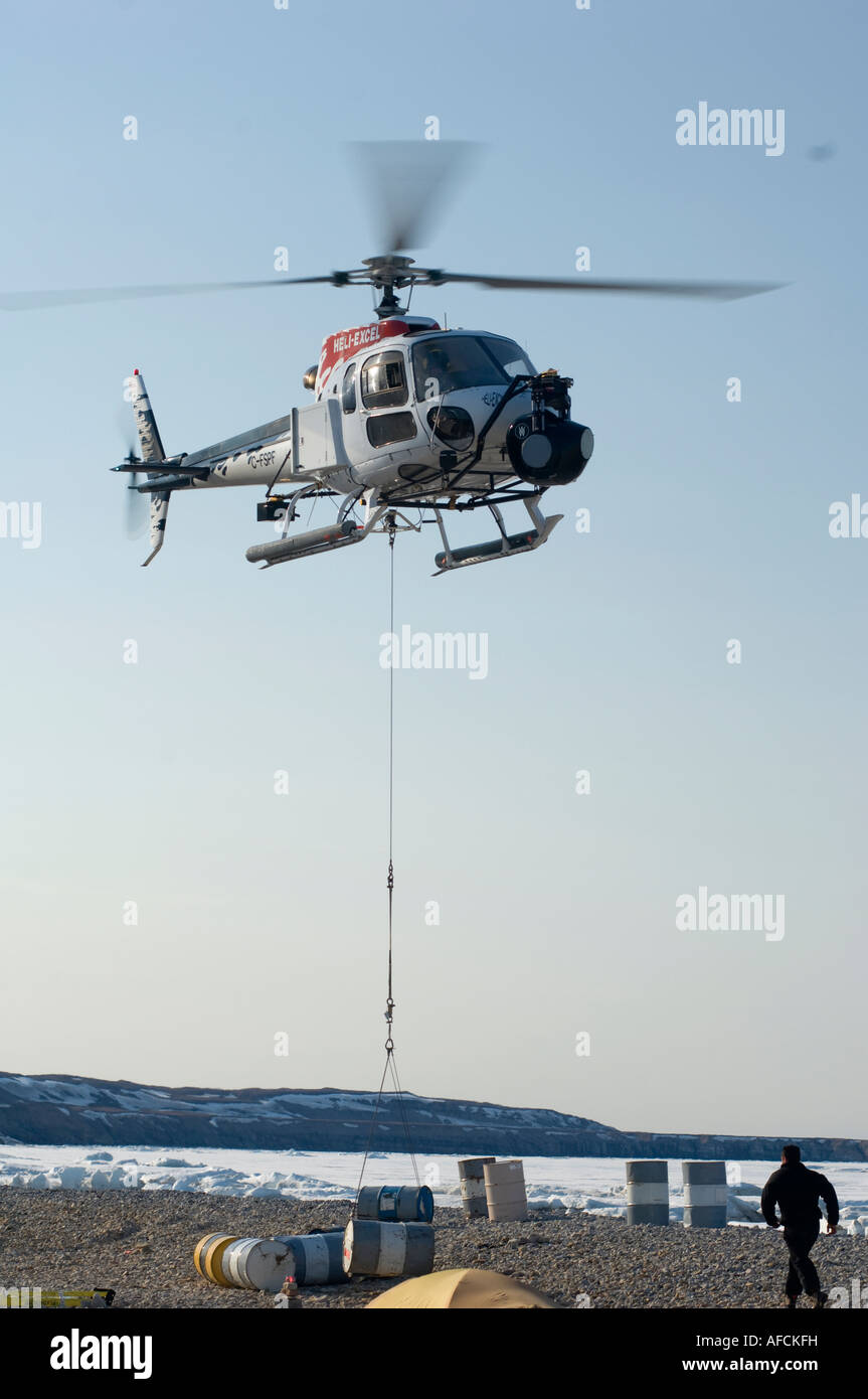 ASTAR 350 B2 Helicopter slinging barrels of jet fuel in remote arctic camp Stock Photo