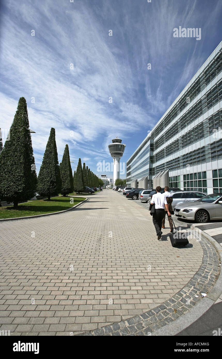 Illustration Airport: Businessmen at Munich Airport exterior view with tower and trees Stock Photo