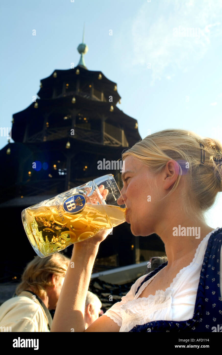 Girl in Dirndl dress drinking beer in beergarden, Chinesischer Turm, English Garden, Munich, Bavaria, Germany Stock Photo