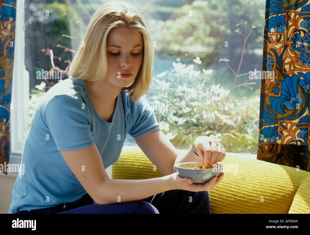 woman eating peanuts from a bowl Stock Photo Alamy