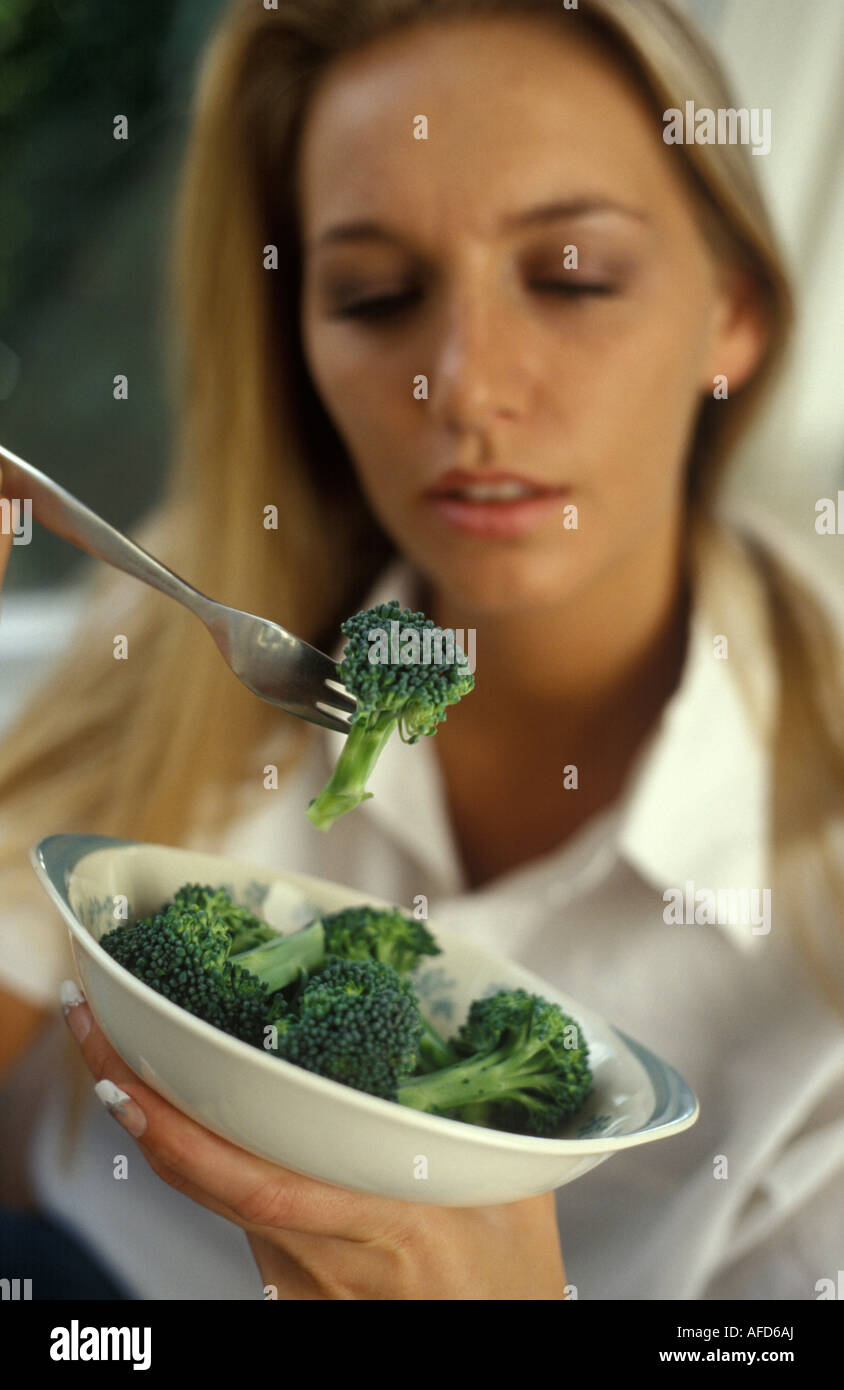 woman eating broccoli Stock Photo