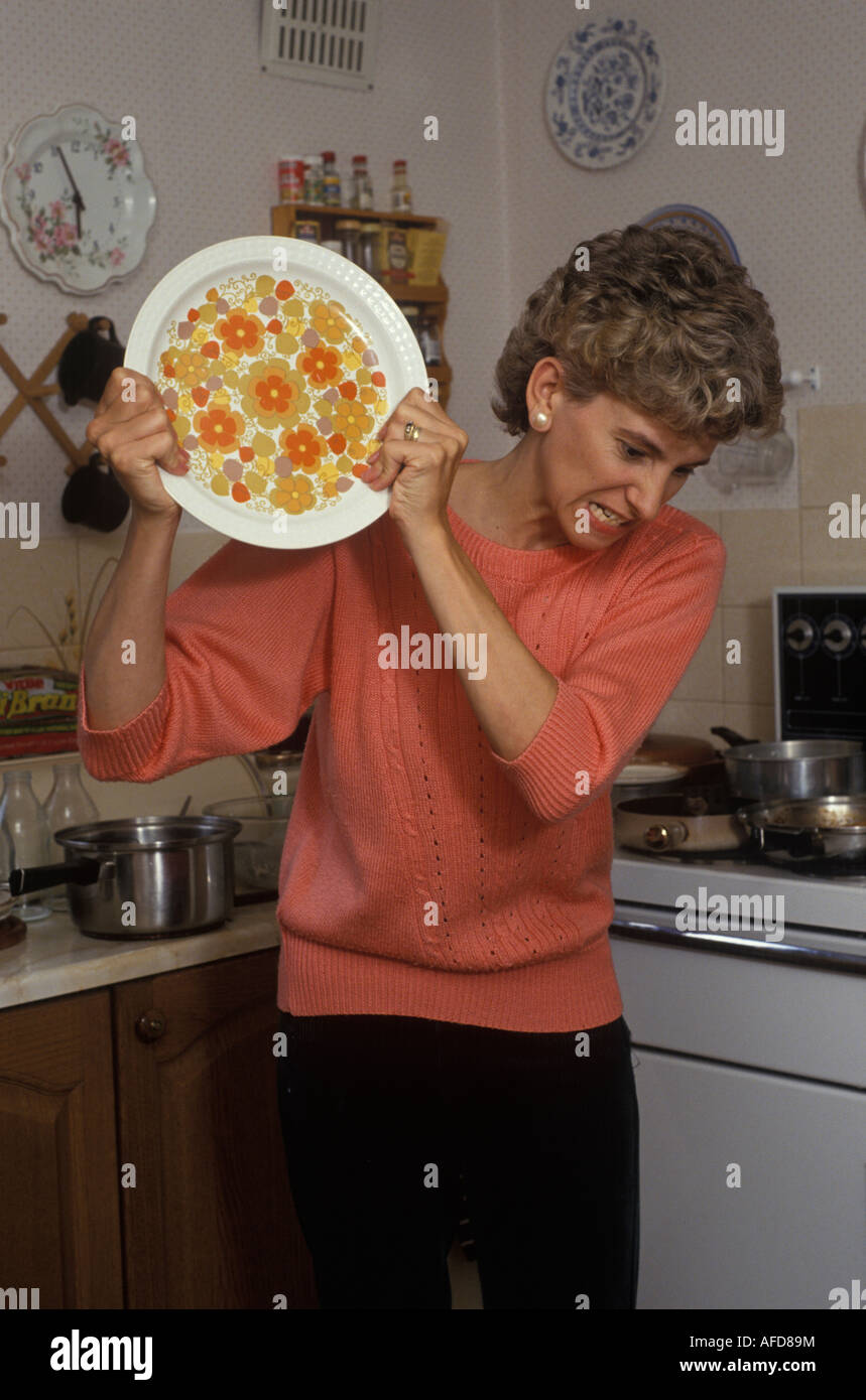 Woman breaking plates in anger Stock Photo