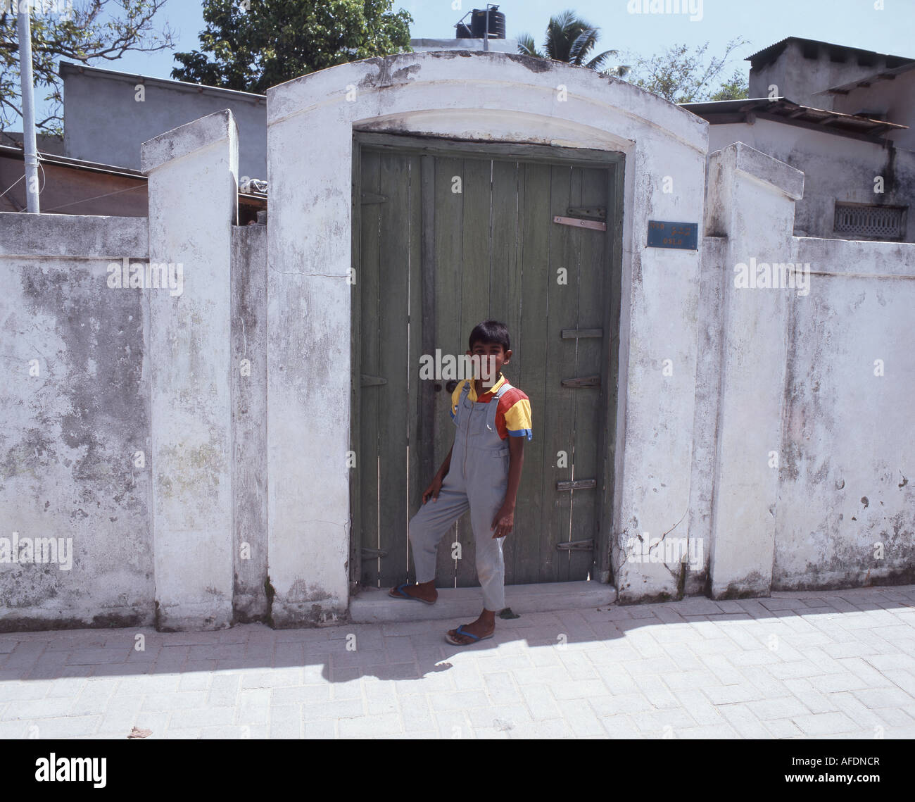 Local boy standing in doorway, Malé, Kaafu Atoll, Republic of Maldives Stock Photo