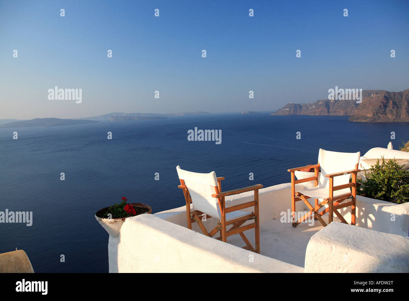 tranquil view of chairs on patio overlooking clear blue ocean Stock Photo