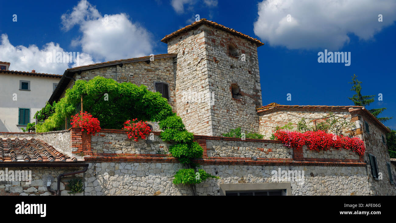Panorama of stone estate with red flowers on rooftop terrace balcony at Radda in Chianti Tuscany Italy Stock Photo