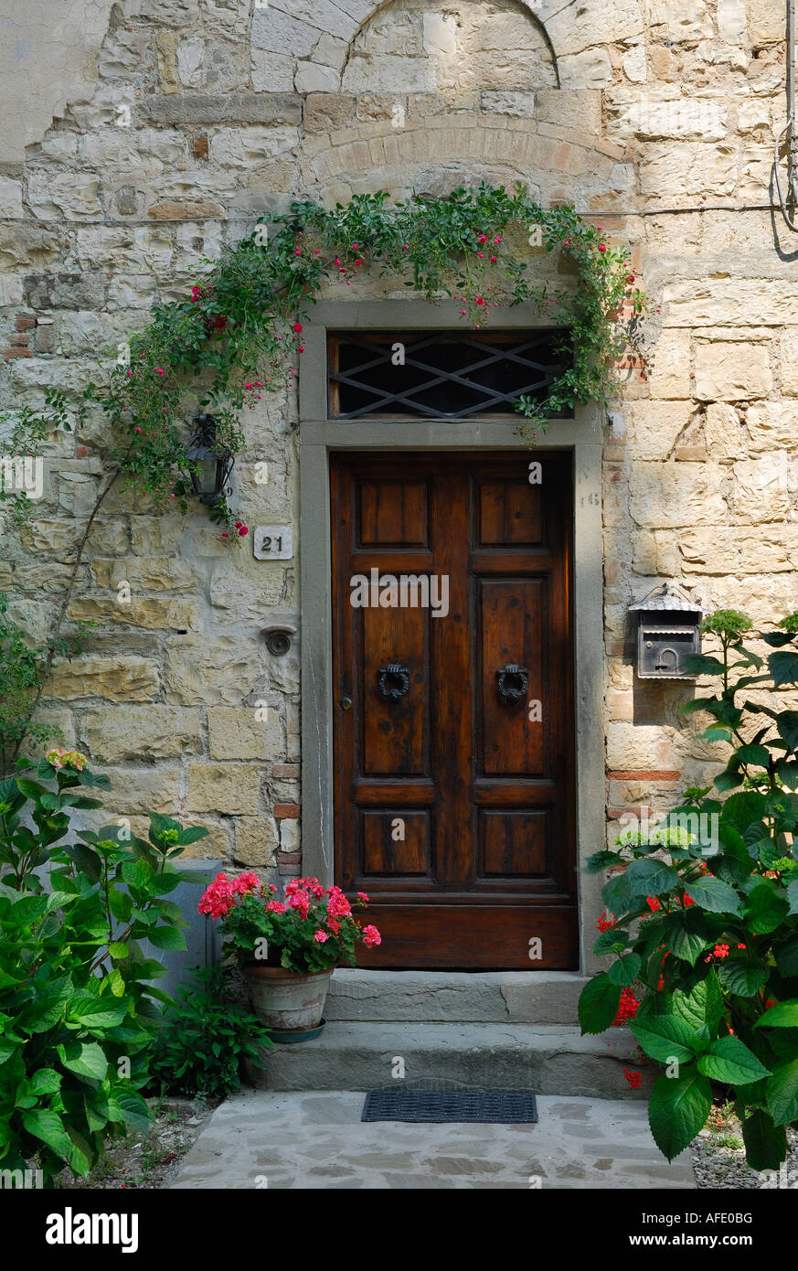 Shaded doorway with potted plants in Passignano Chianti Tuscany Italy Stock Photo