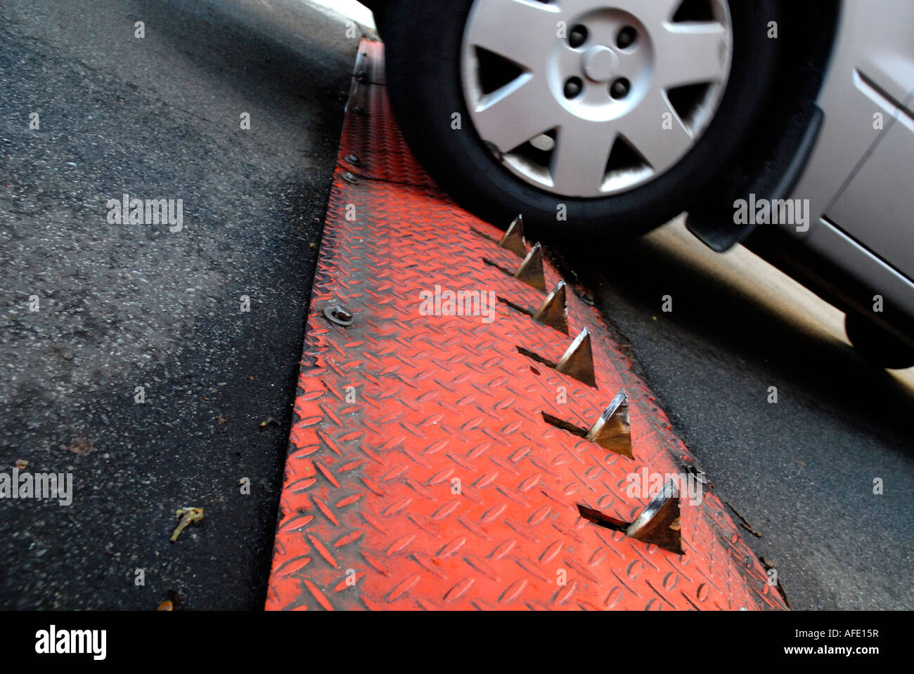 car driving over traffic control barrier with metal spikes Stock Photo