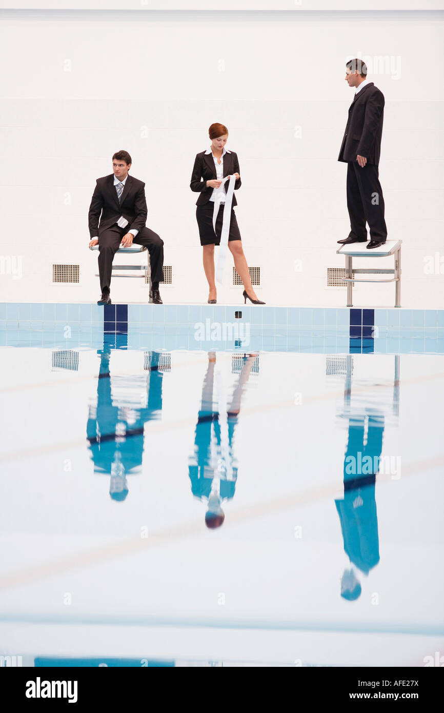 Businessmen on starting blocks, woman holding roll of paper Stock Photo ...