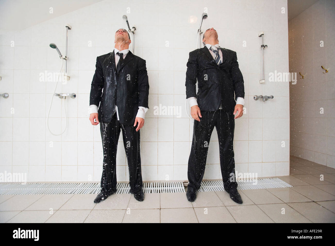 Businessmen standing under shower Stock Photo
