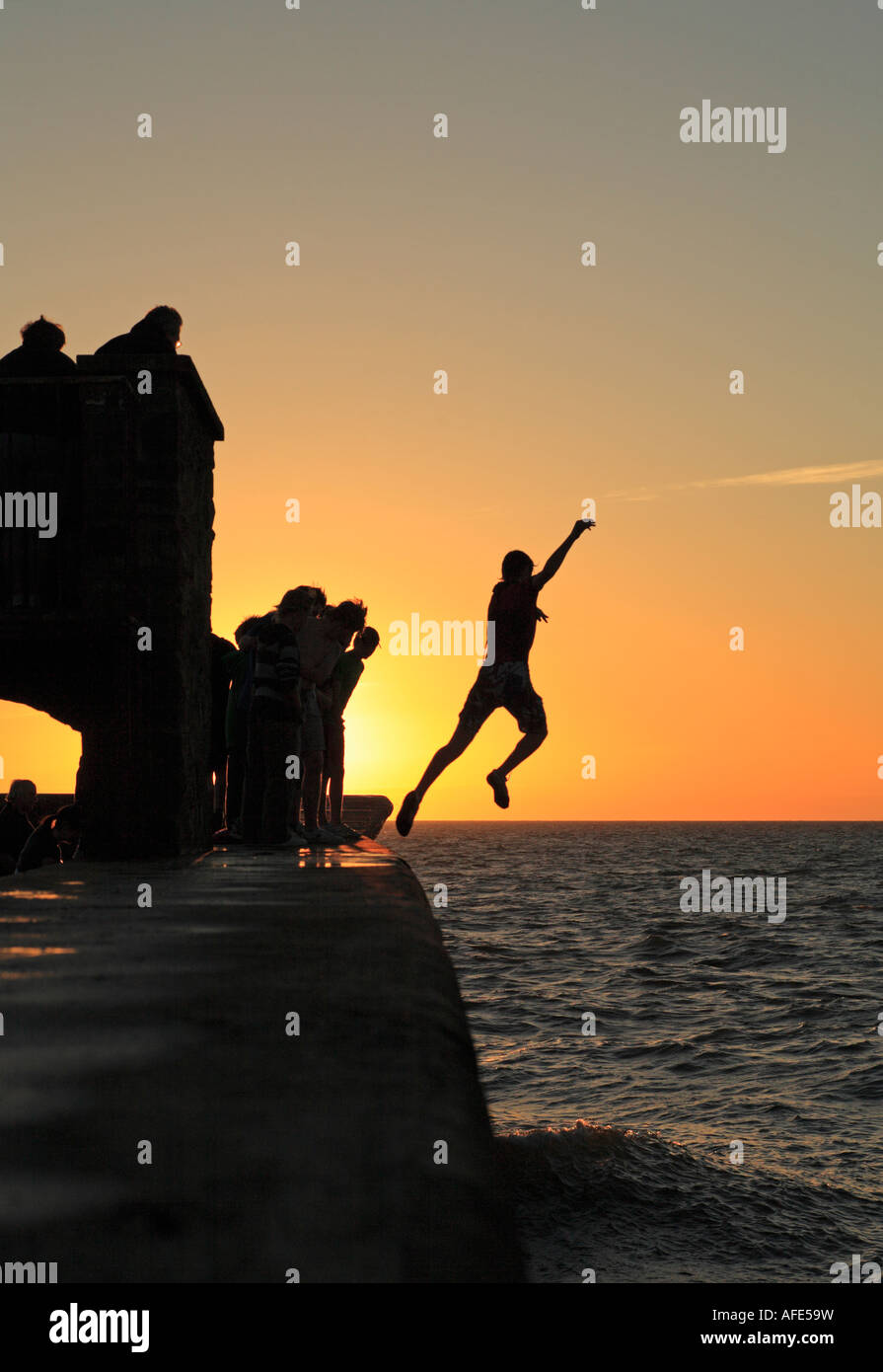 Young man tombstoning - jumping into the sea. Stock Photo