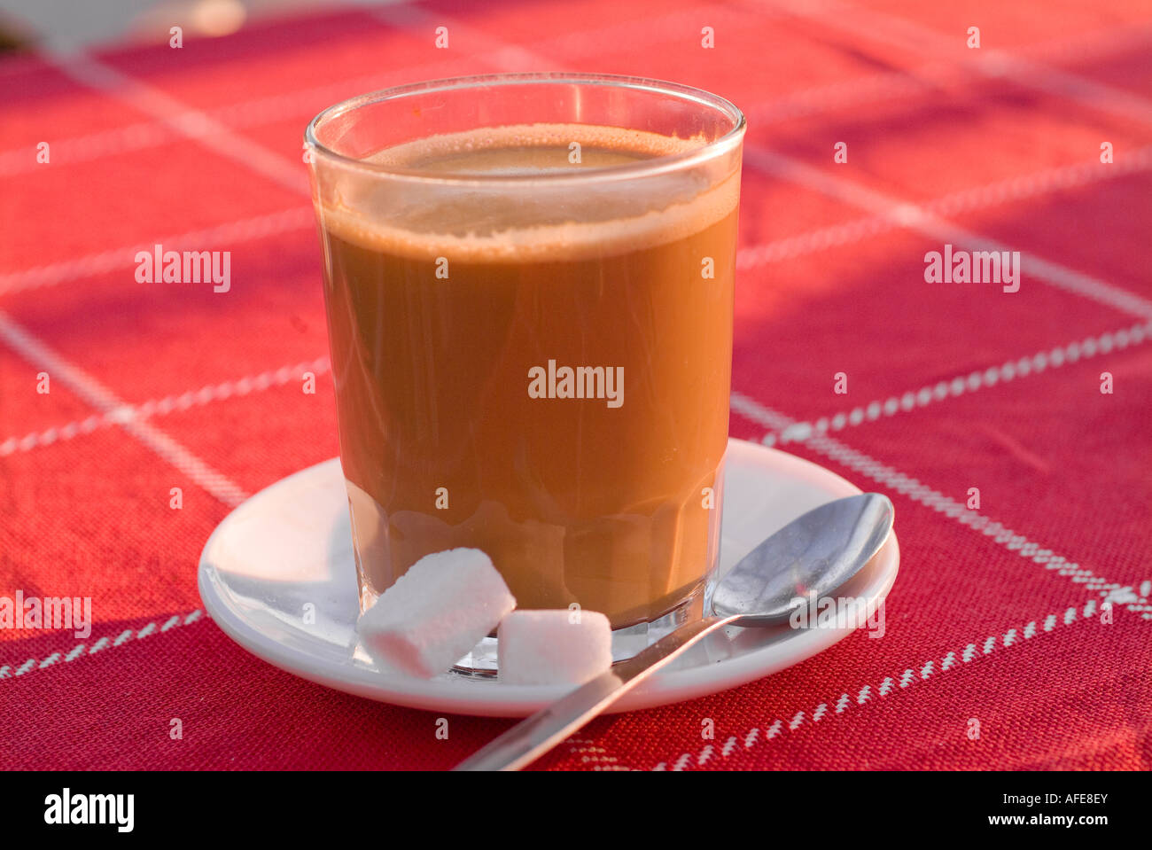 Cafe latte in clear glass cup on red tablecloth Stock Photo