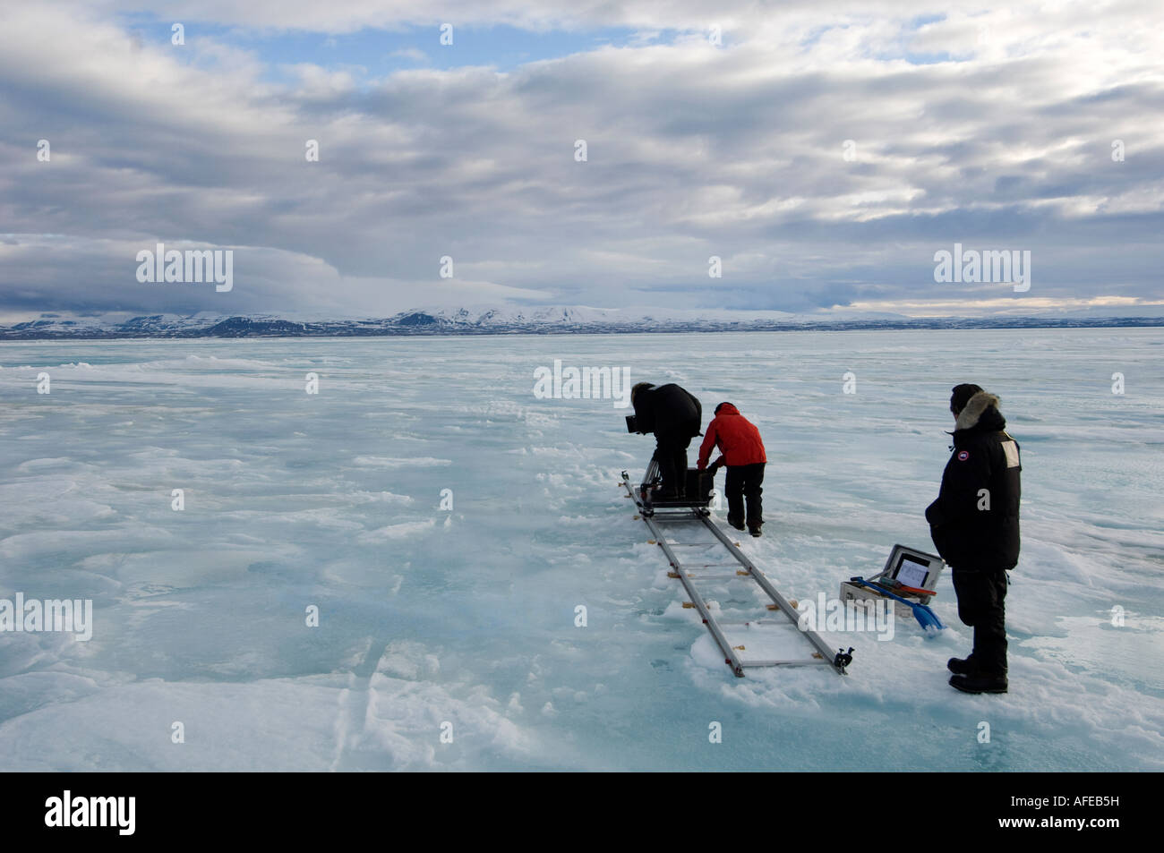 Film crew working in the high arctic movie camera on rails and dolly to facilitate movement Stock Photo