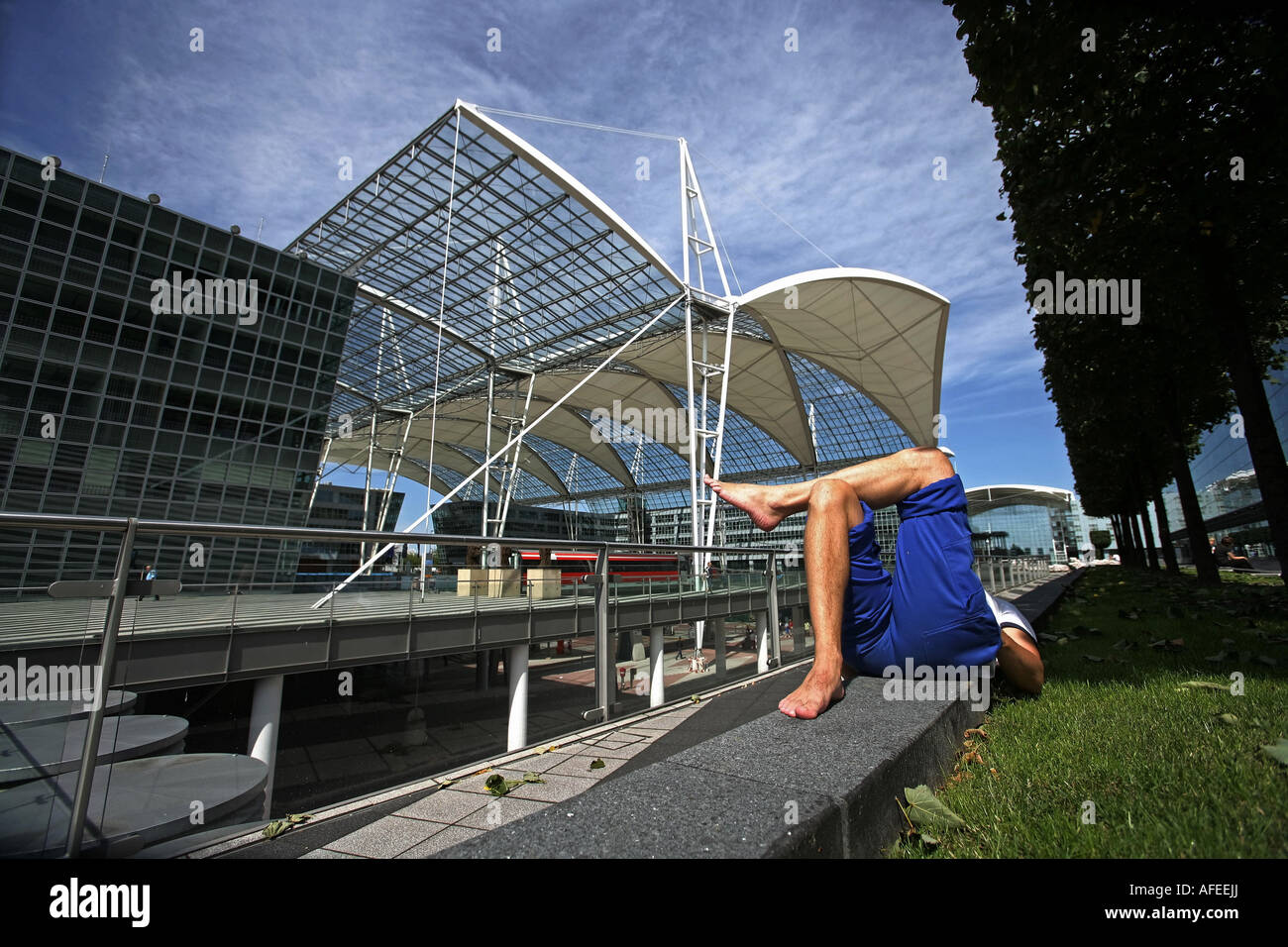 Illustration Airport Terminal 2: Traveler is sleeping at the parc of the modern Munich Airport building Stock Photo