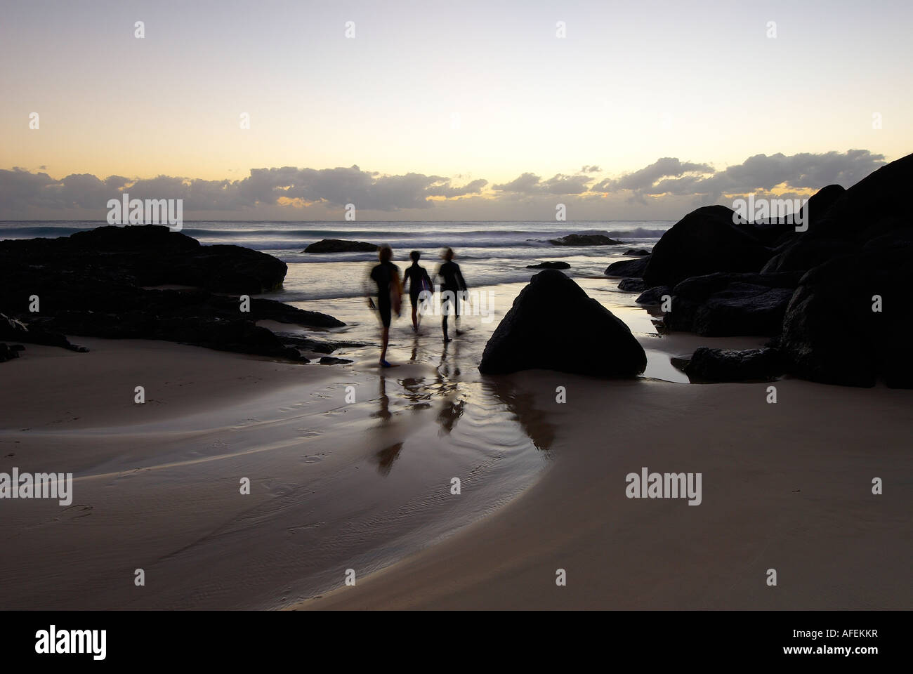Surf board riders going for dawn ride at Little Cove on the Gold Coast Australia Stock Photo