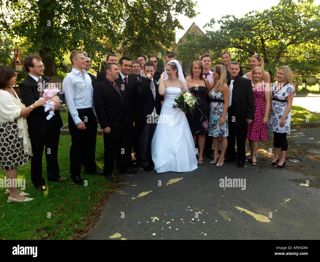 Bride and Groom Pose for Photograph with Friends Outside St Marys Church Caterham Stock Photo