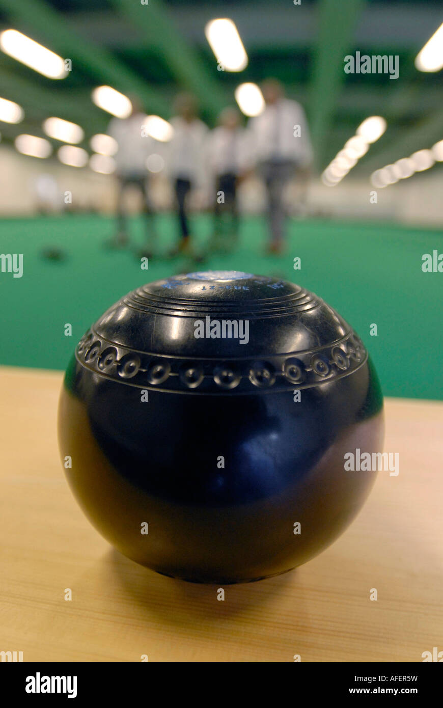 Bowling ball and bowlers at an indoor bowls green Stock Photo
