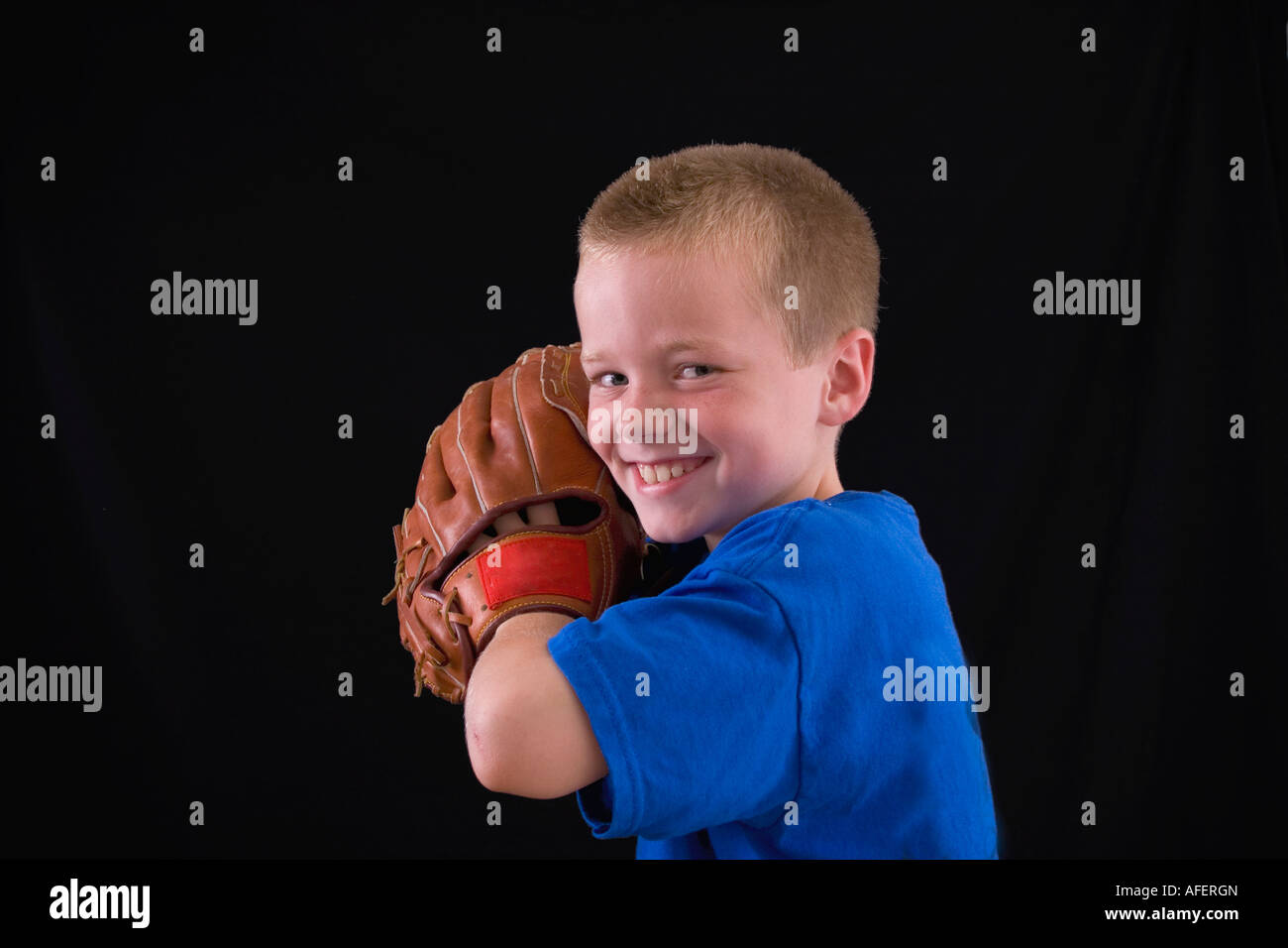 Cute little eight year old boy with a ball and a glove Stock Photo