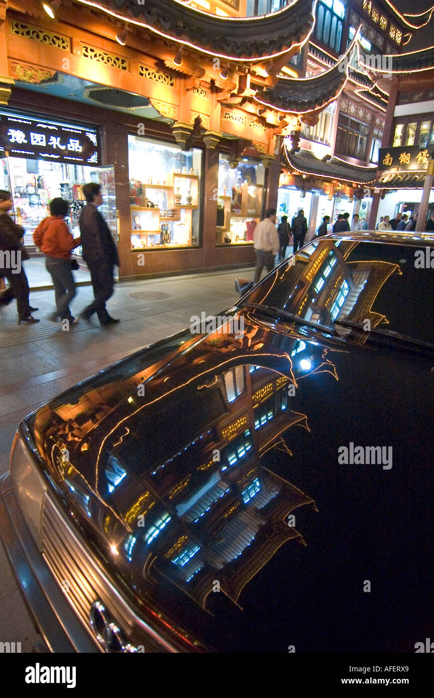 Illuminated buildings in the Yuyuan garden area being reflected onto a flashy black car in Shanghai, China Stock Photo
