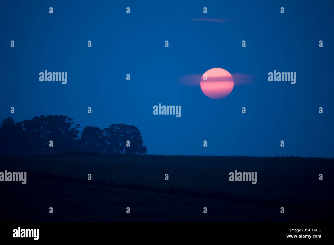 Setting Sun over rural landscape Stock Photo