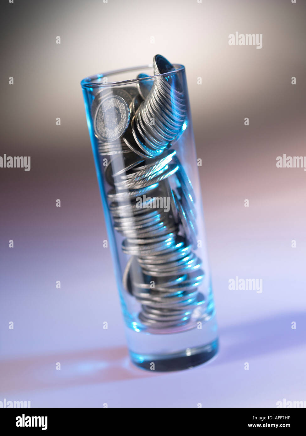 glass filled with coins Stock Photo