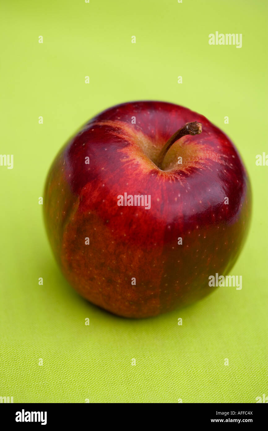 Whole red apple on green background Stock Photo - Alamy