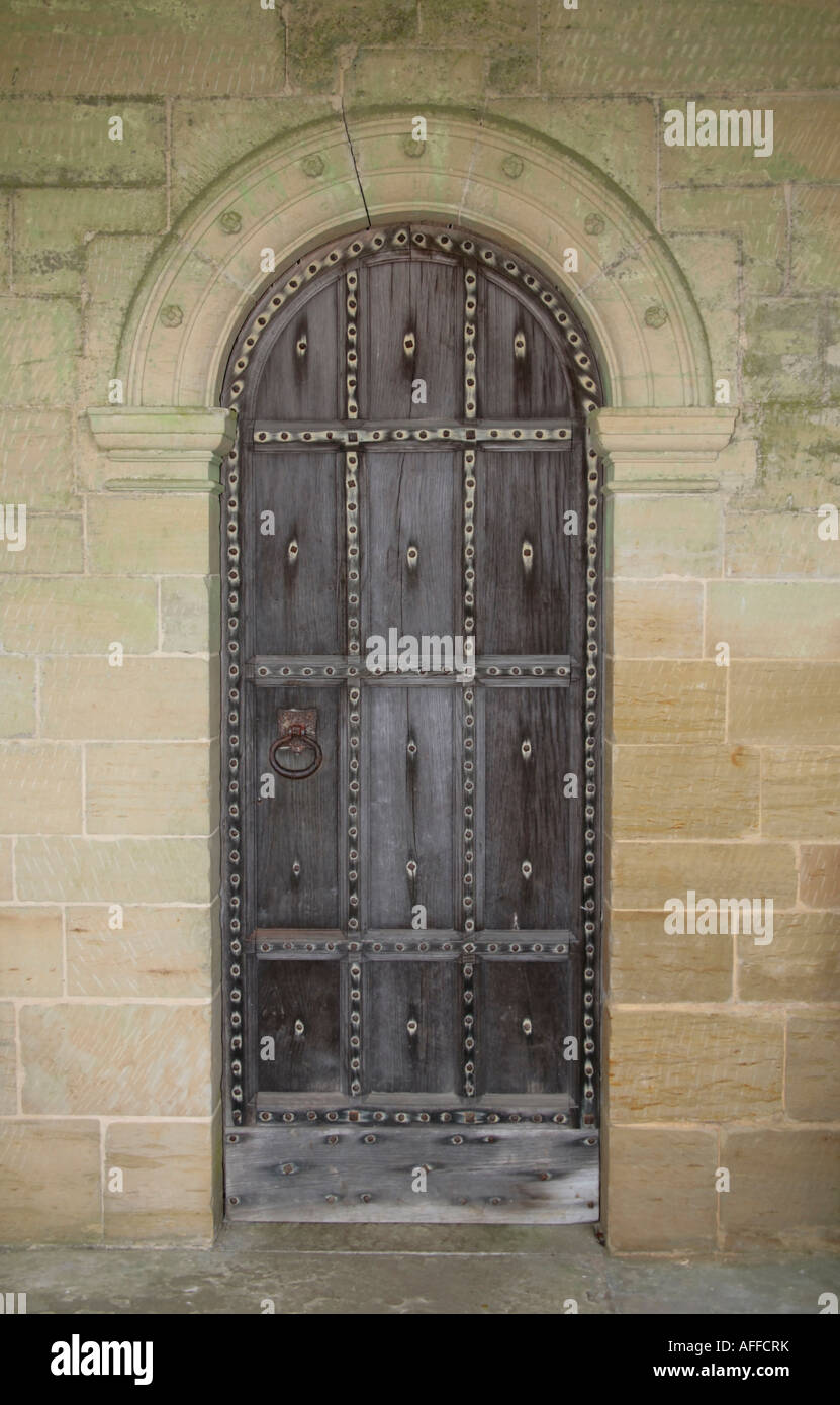 Old arched studded wooden door Stock Photo