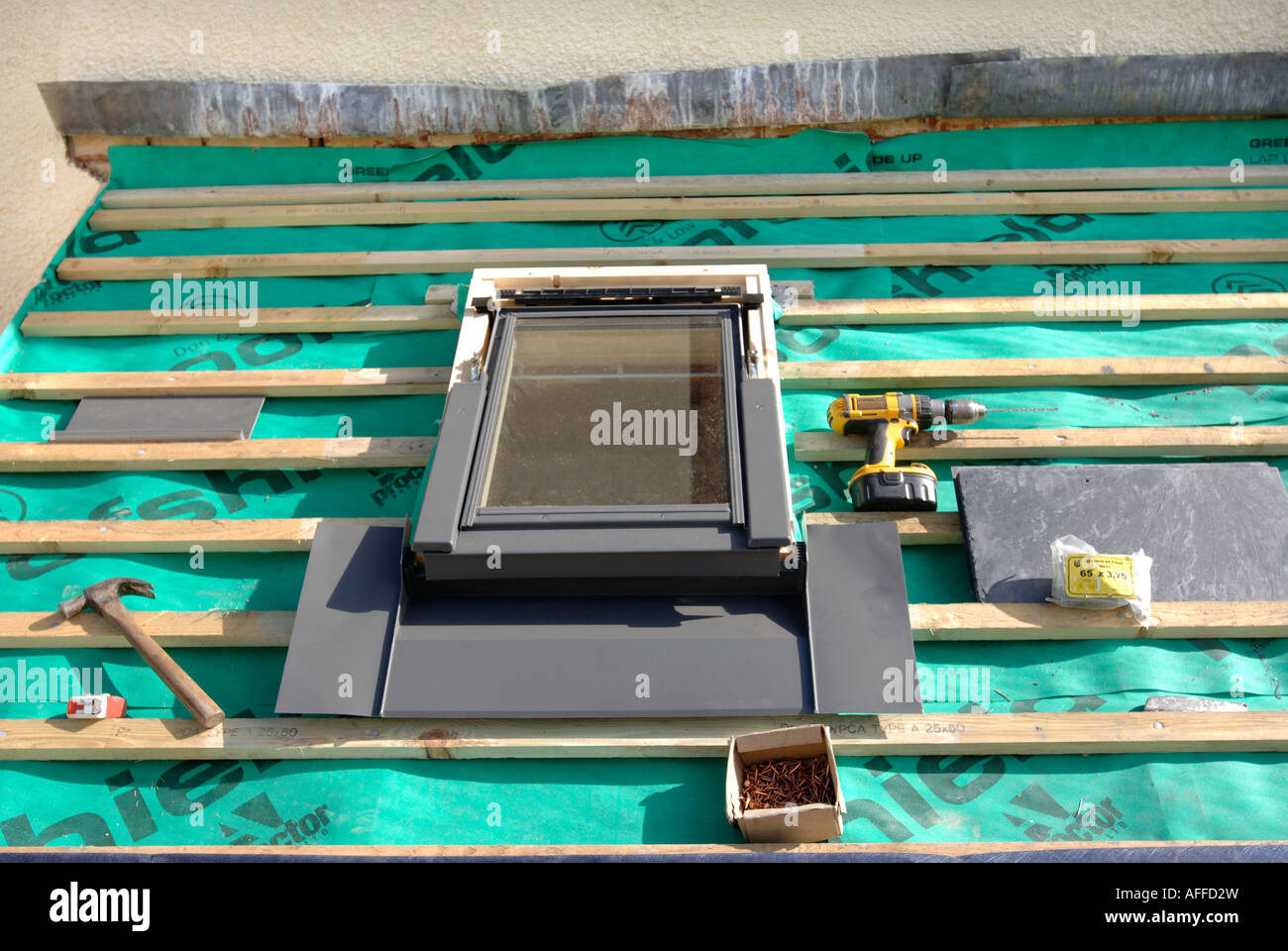FITTING A VELUX WINDOW ON A SLATE ROOF UNDER CONSTRUCTION SHOWING THE