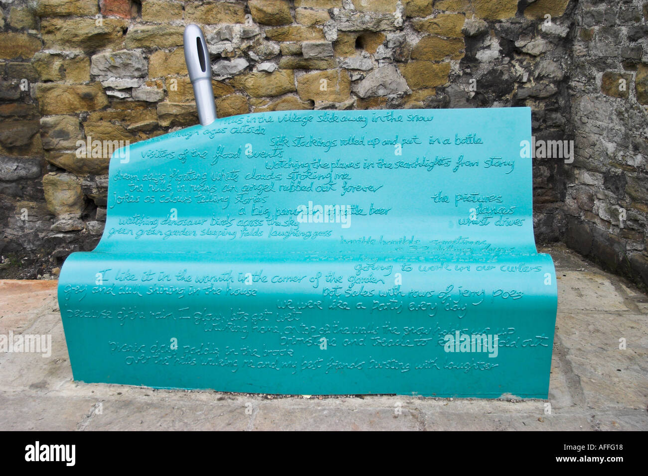 A bench in Eyam Derbyshire UK The bench is in the style of a piece of silk cloth with a needle behind it Stock Photo