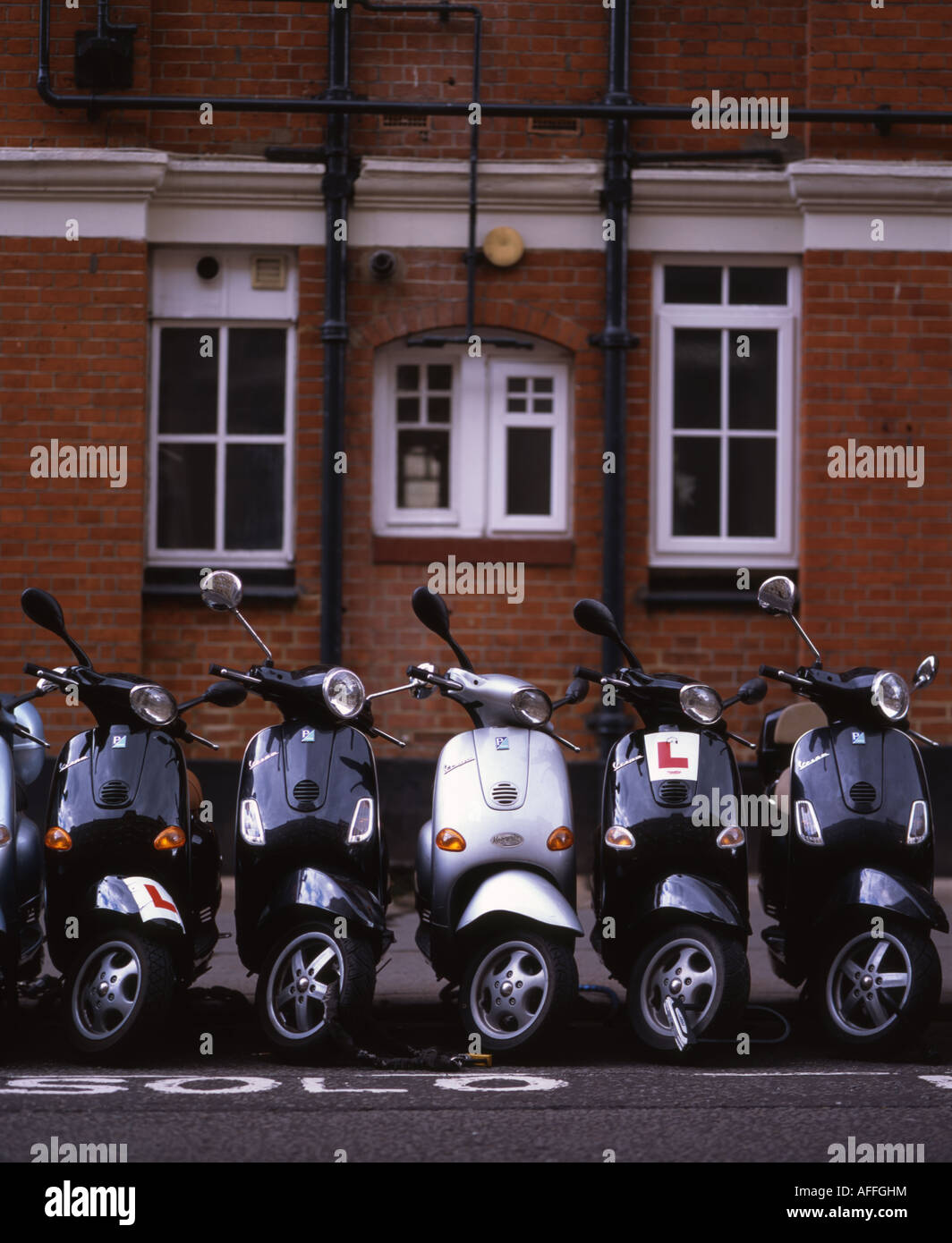 Line of Vespa scooters parked in city center london Stock Photo