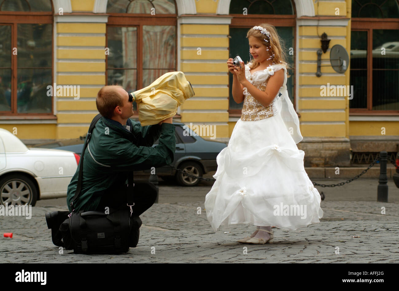 Cameraman shooting a video of a young bridesmaid wearing a white dress at a  Russian wedding in St Petersburg Russia Stock Photo - Alamy