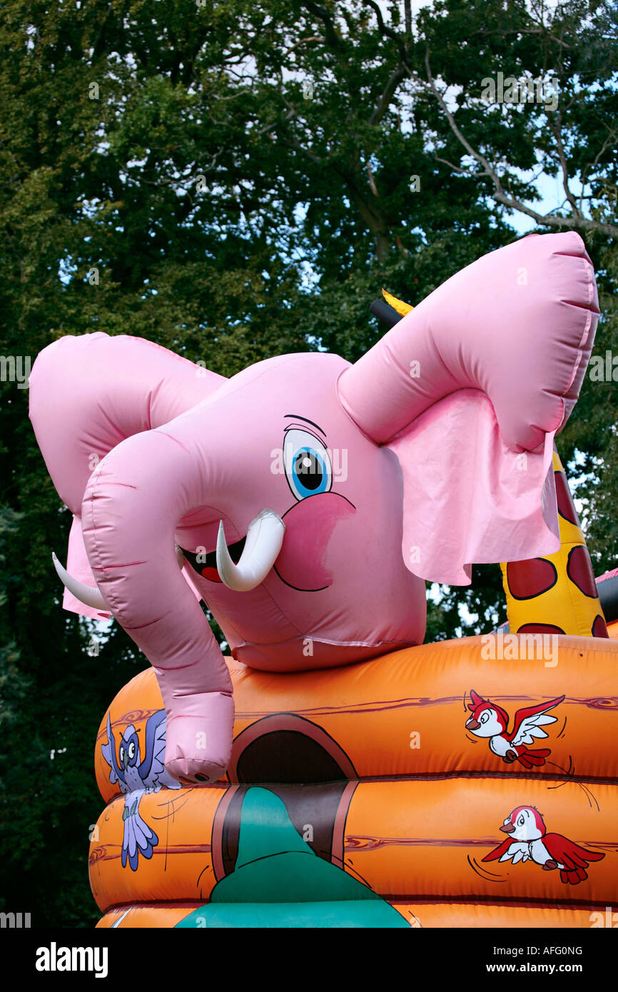 Pink plastic inflatable elephant on bouncy castle Stock Photo