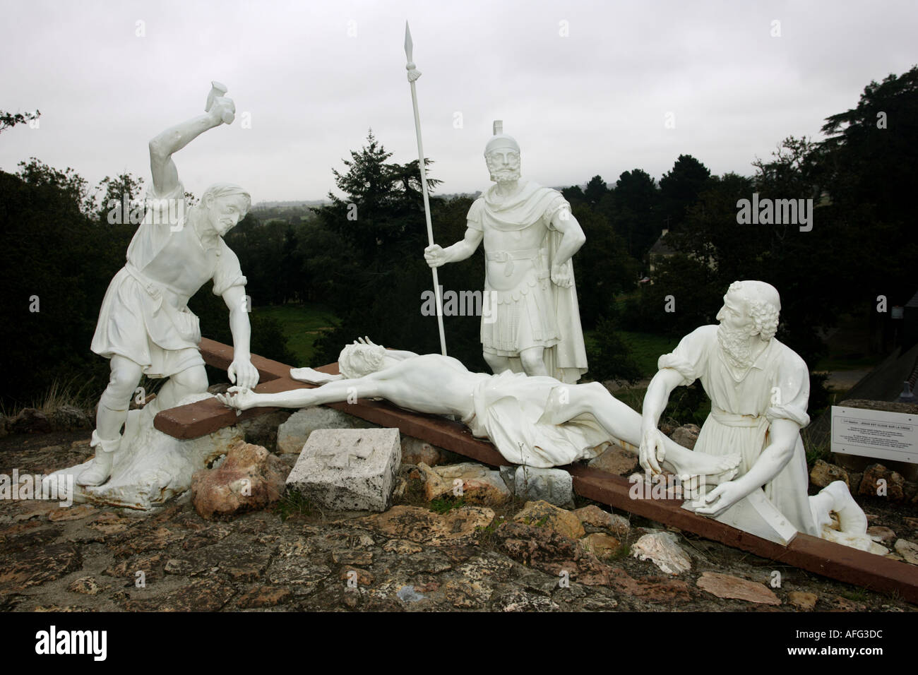 Life size statues of Christ being nailed to the crosss Le Calvare Nr Pontchateuax Brittany France Stock Photo