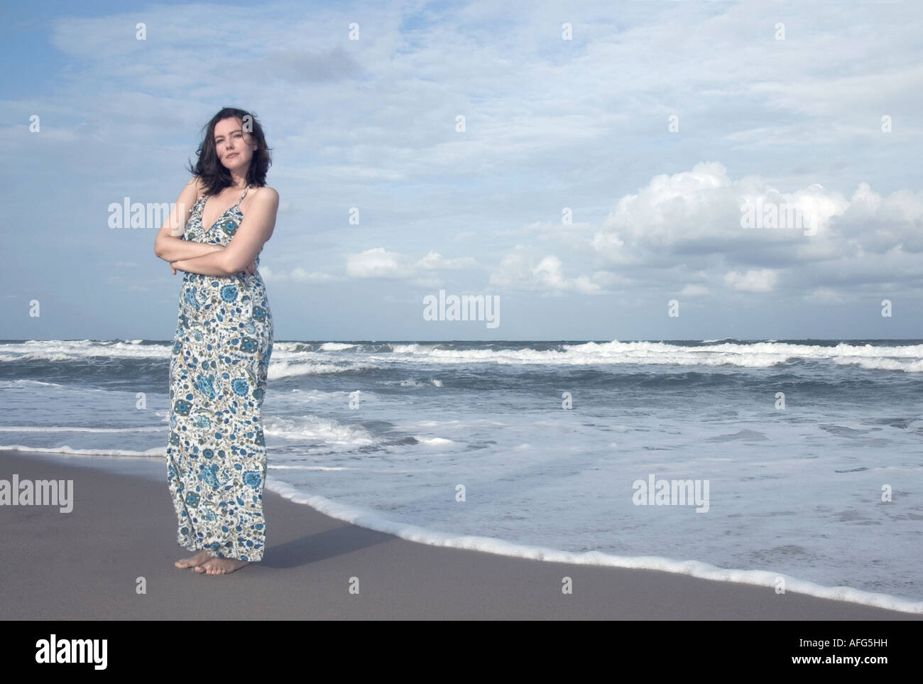 Young woman standing on the beach Stock Photo - Alamy