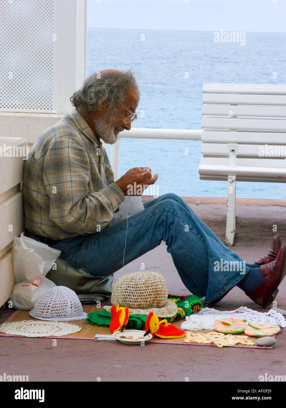 This man crochets small items on the Promenade des Anglais and invites contributions from the public - Nice, France Stock Photo